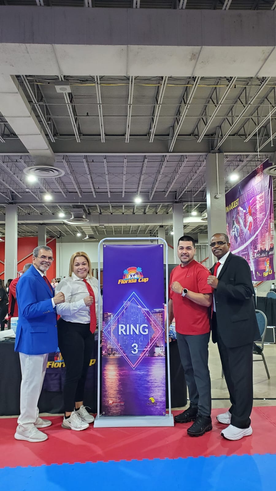 three taekwondo instructors and a female referee at a tournament